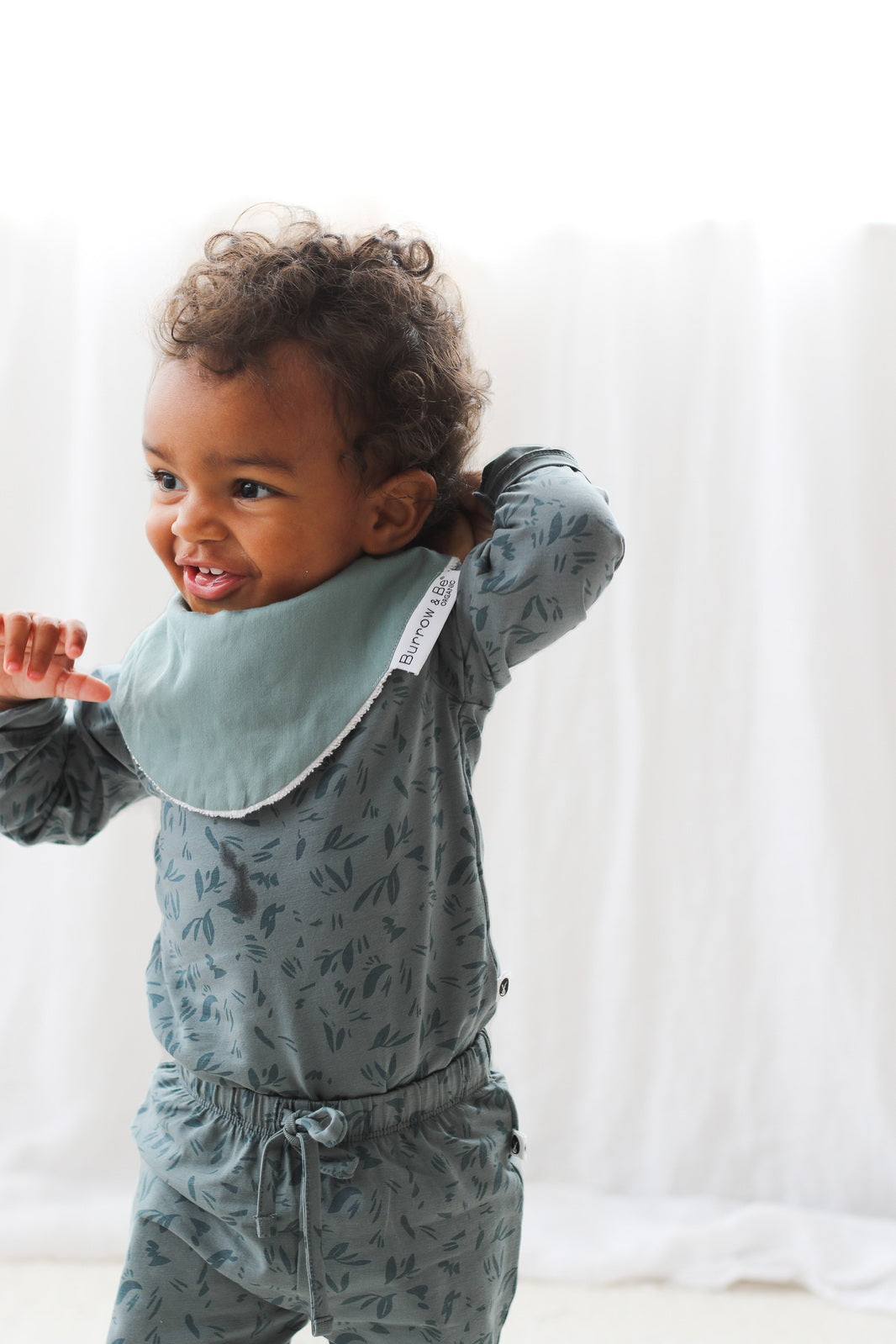 Baby wearing green Burrow and Be dribble bib and Marks Long Sleeve Bodysuit_3