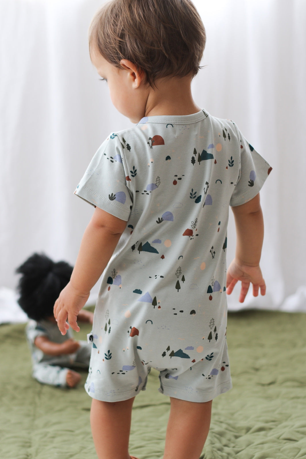 Back view of kd wearing Garden Treasure Alex Romper from Burrow and Be