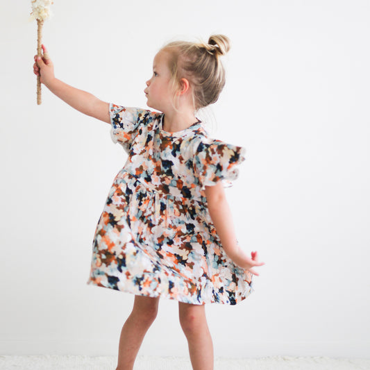 Girl looking to her right holding a wand and wearing Delight Ella Dress by Burrow and Be