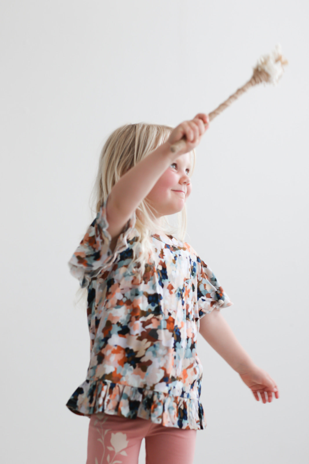 Girl posing in front of a white background while wearing Delight Ella Top and Mead Bike Shorts, both designed by Burrow and Be