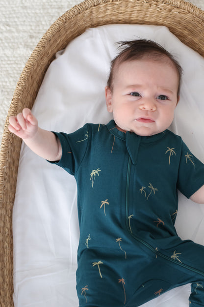 Baby in moses basket wearing Burrow and Be Palm Zip Suit