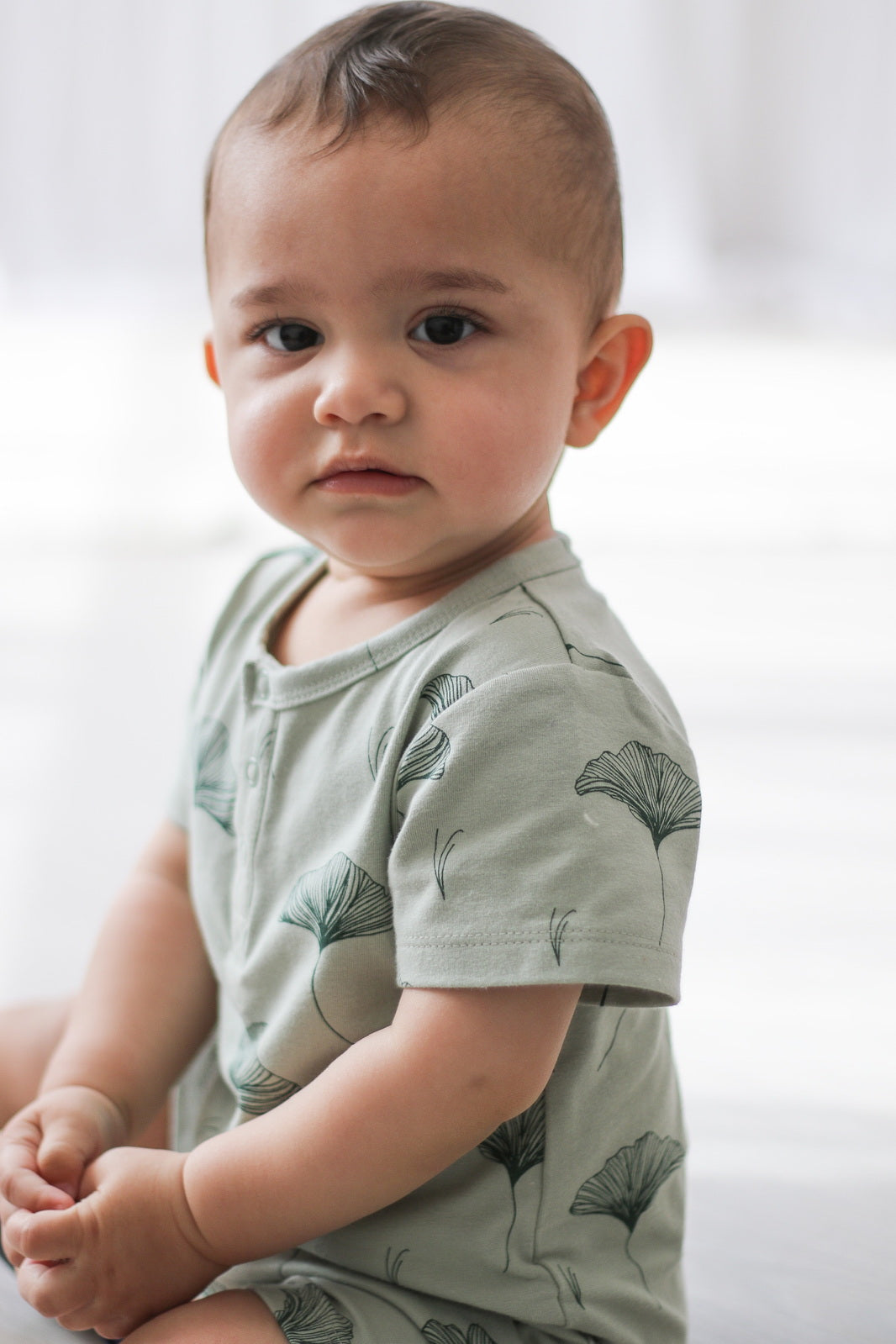 Baby staring at the camera while wearing Ginkgo Alex Romper from Burrow and Be